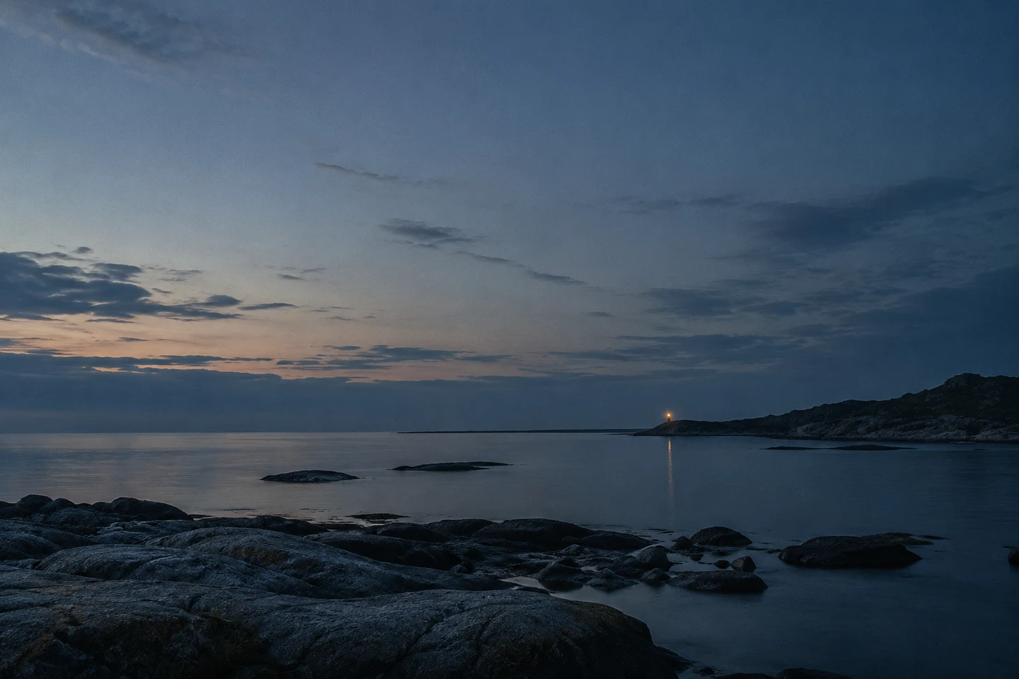 蓝调暮色中的安静海岸，一点暖光映在远处